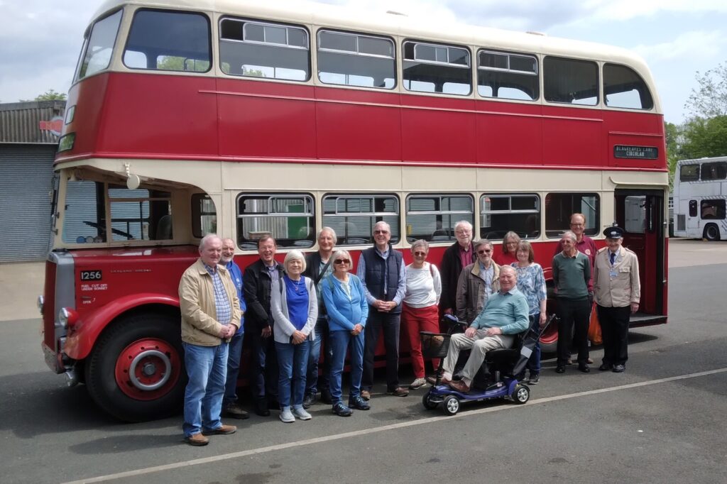 Members standing beside a double-decker 'Midland Red' bus
