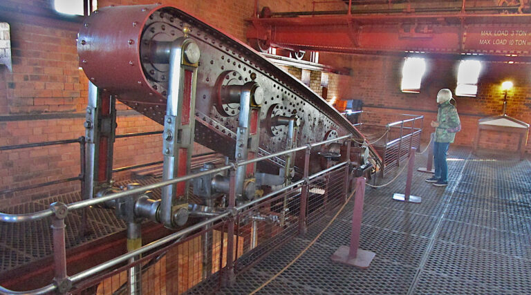 Walkway surrounding huge wrought-iron beam of vertical stem engine.