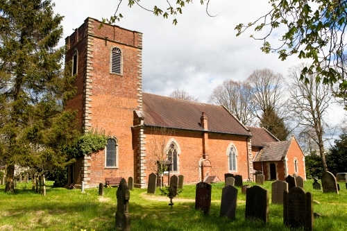 Phot of outside of St Swithin's Church Barston with cemetery in the foreground