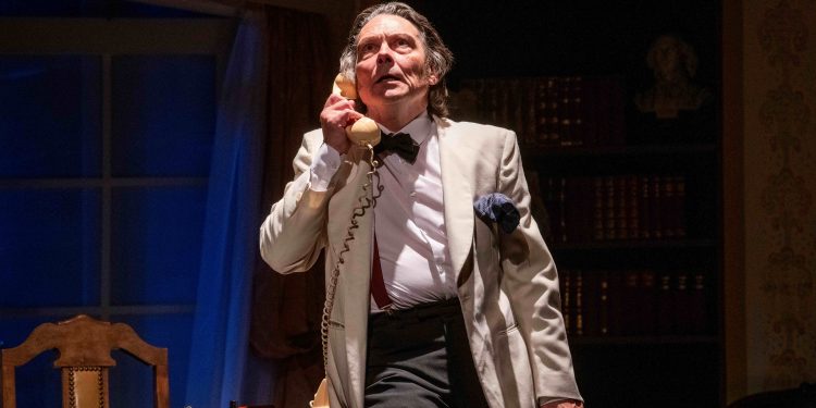 A well dressed gentleman, rather haggard appearance, is listening to a telephone call. He is clearly disturbed by the content of the call.