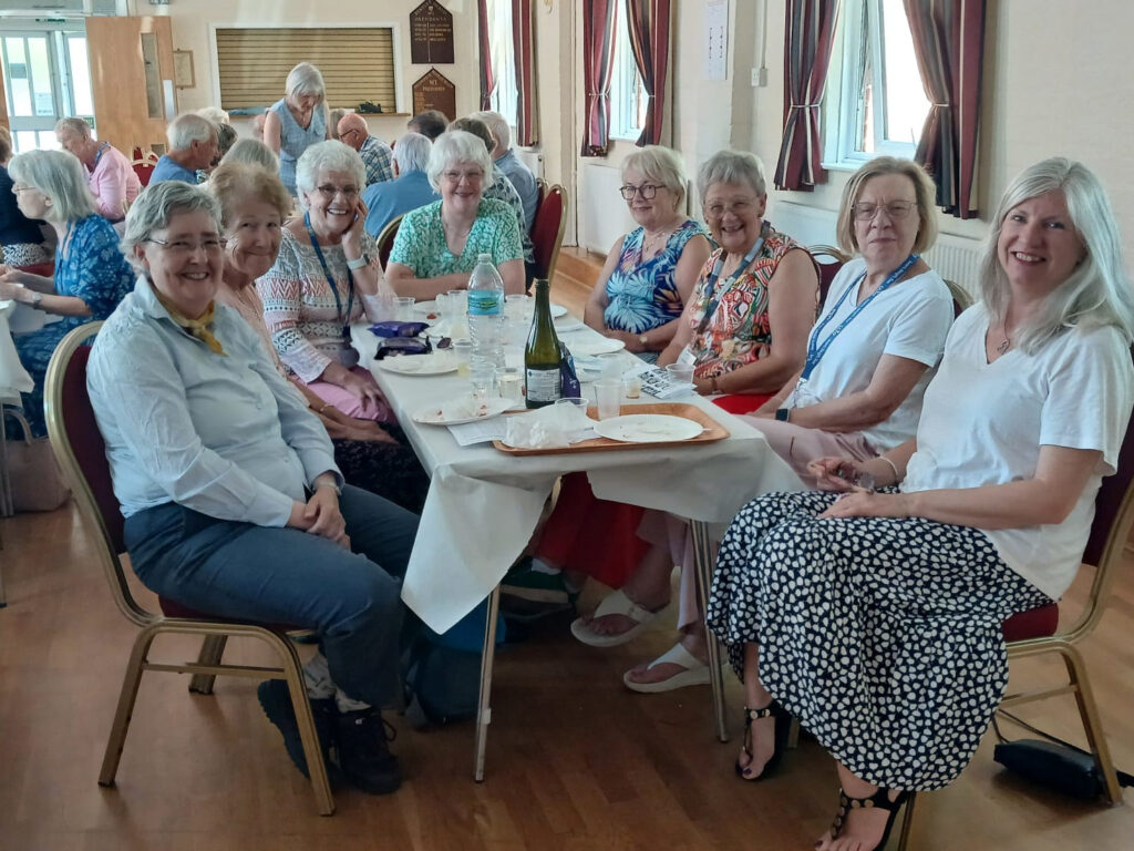 Members gathered around tables at the Bentley Heath Community Centre, enjoying the Cream Tea at our 15-year anniversary celebration.